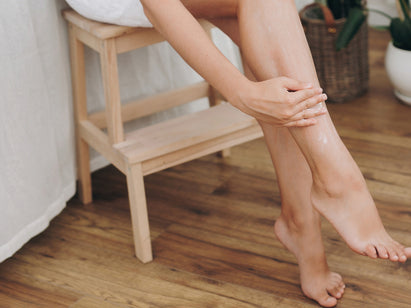 woman rubbing cream into her legs