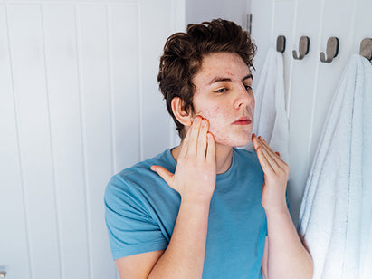 Teenage boy applying skin care