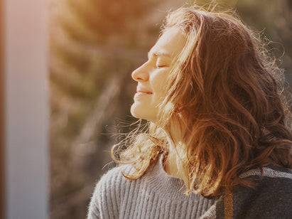 Woman facing the sun in cold month