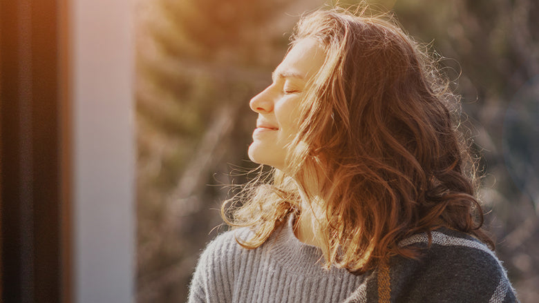 Woman facing the sun in cold month