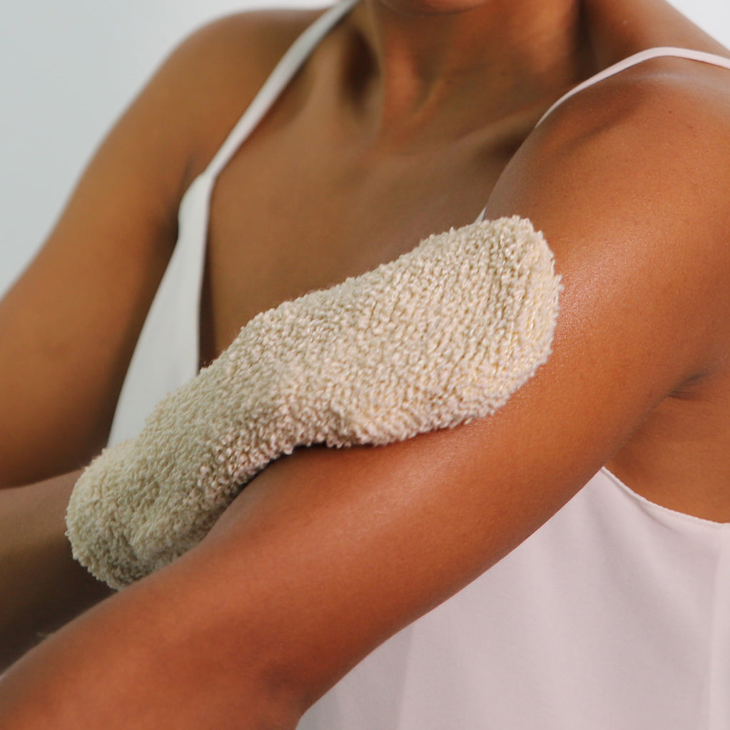 person using the exfoliating mitt