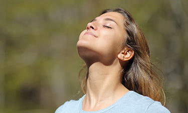 banner for natural spf moisturiser category featuring woman smiling in sunshine