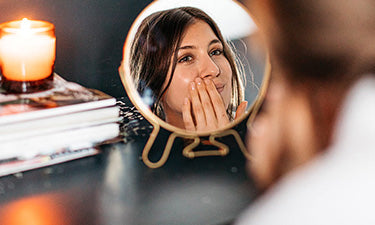 banner for natural face cream category with woman looking in mirror