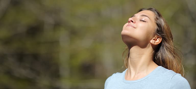 banner for natural spf moisturiser category featuring woman smiling in sunshine